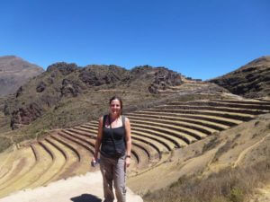 girl stood in front of some terraces that go down a mountain side